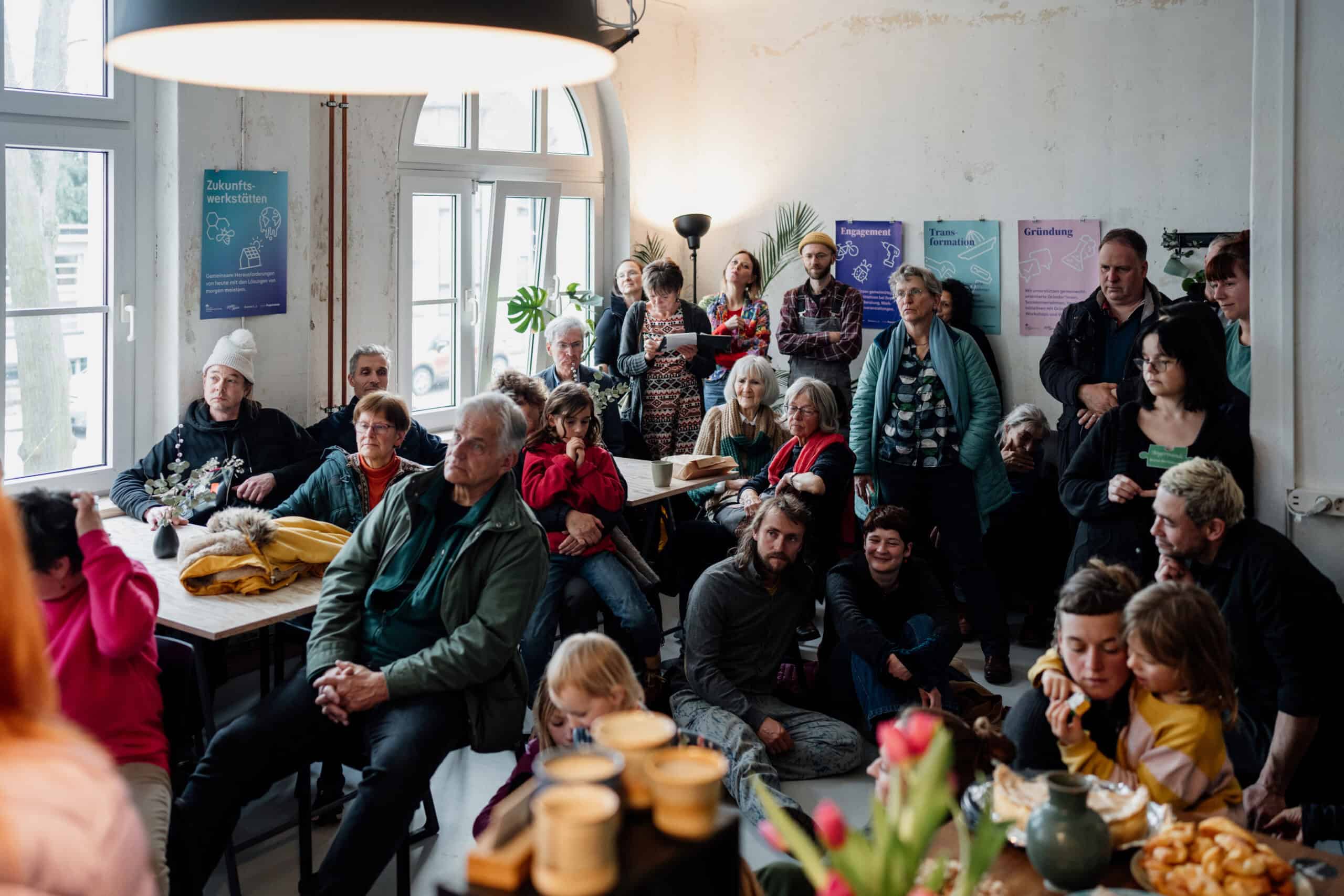 Menschen bei der Kunstveranstaltung AngerWERK in einem hellen Raum.