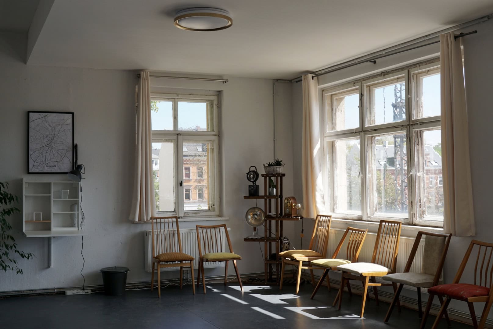 Heller, gemütlicher Raum mit Stühlen und großen Fenstern für Treffen oder Wartebereich.