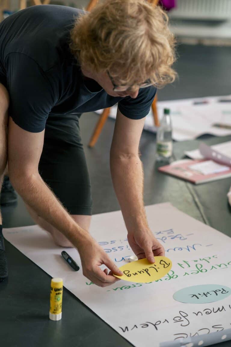 Kreative Person schreibt auf ein Flipchart während eines Workshops oder Brainstormings.