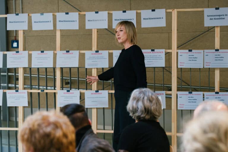 Mann spricht vor Publikum bei Projektpräsentation.