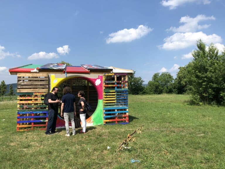 Kunstinstallation aus recycelten Paletten mit bunten Akzenten im Freien.