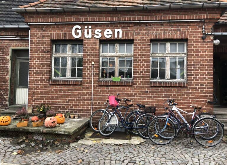 Historisches Backsteingebäude in Güsen mit Fahrrädern und Halloween-Dekorationen.
