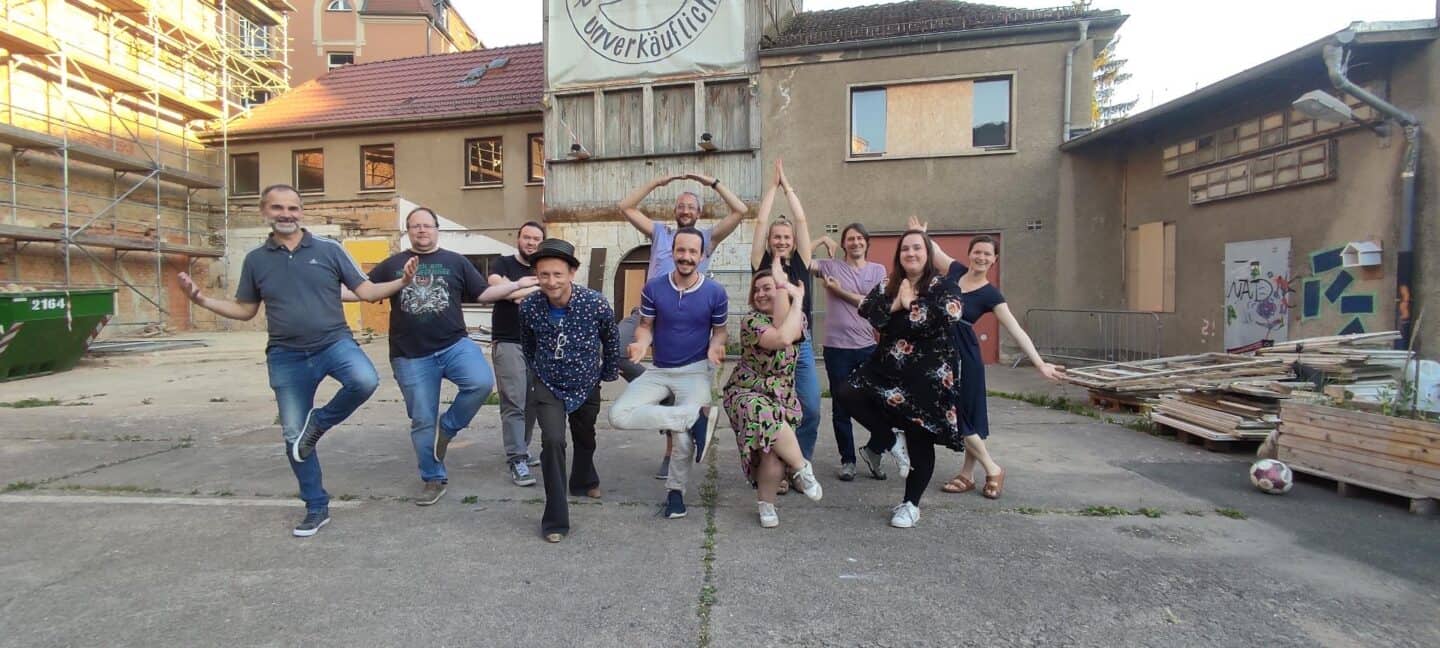 Menschengruppe beim Aufbau eines Netzwerks im Baugebiet, fröhliche Stimmung.