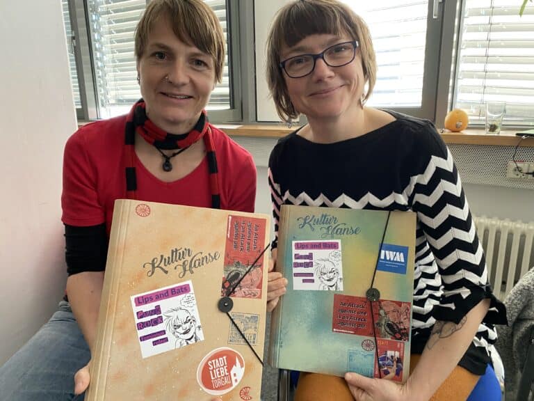 Zwei Frauen mit Bastelbüchern in Torgau, Stadtführerin und Teilnehmerin.