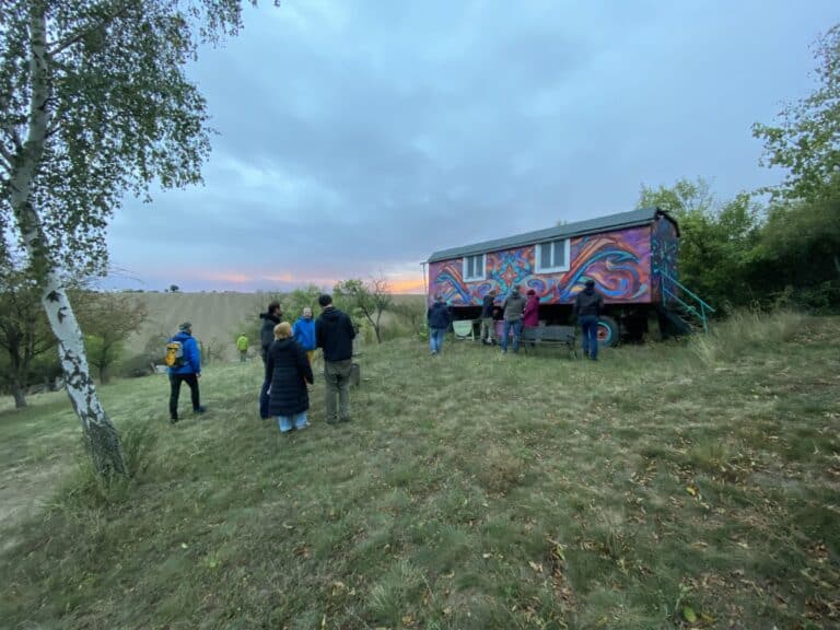 Kunstinstallation im Freien mit mehreren Besuchern bei Sonnenuntergang in Zappendorf.