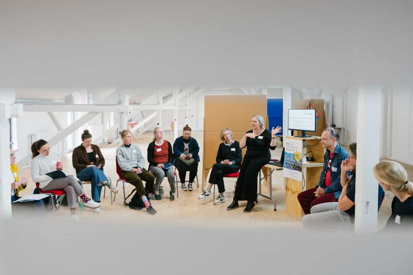 Kunst-Workshop im Raum mit Teilnehmern und Kursleiterin.