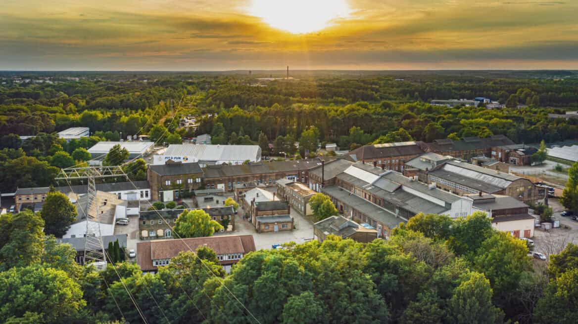 Rofinpark mit Industriegebäuden und grüner Umgebung bei Sonnenuntergang.
